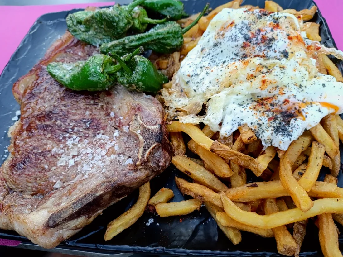 Chuleta de ternera con patatas caseras, pimientos del padrón y huevo